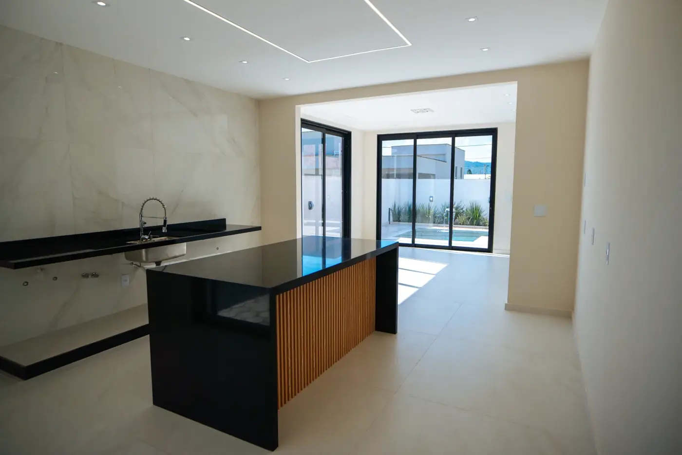 Cozinha com ilha central e bancada preta.