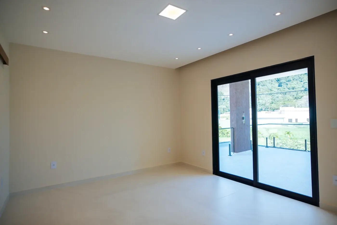 Quarto amplo com esquadria de correr e vista para fora.