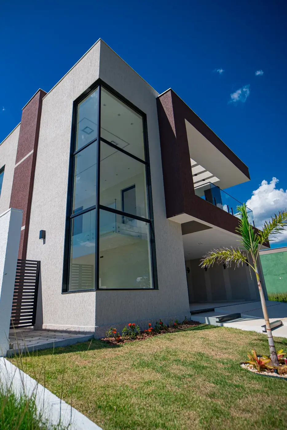Fachada em ângulo, com o painel de vidro que ilumina o pé-direito duplo da escada.